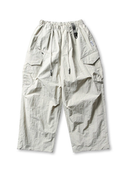 超ワイドシルエットのエアリーパラシュートパンツ。撥水・防風・速乾性に優れたナイロン生地。ゴムとドローコードのウエスト、調節可能な脚口アジャスター付き。アウトドアやストリートに最適なユニセックスデザイン。