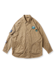 胸と肩にバッジ刺繍、襟付き・ルーズフィット・大フラップポケットが特徴のアウトドアワークシャツの全体像。