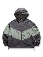 バイカラーフード付きマウンテンジャケットの全体正面画像、幾何学ストライプパッチワークと調節可能ドローコードのディテール。