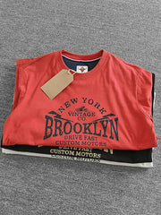製品画像: BROOKLYNヴィンテージプリント長袖Tシャツの全体展示 詳細画像: Tシャツの裾にあるパッチワークデザインのディテール
