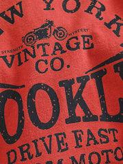 製品画像: BROOKLYNヴィンテージプリント長袖Tシャツの全体展示 詳細画像: Tシャツの裾にあるパッチワークデザインのディテール