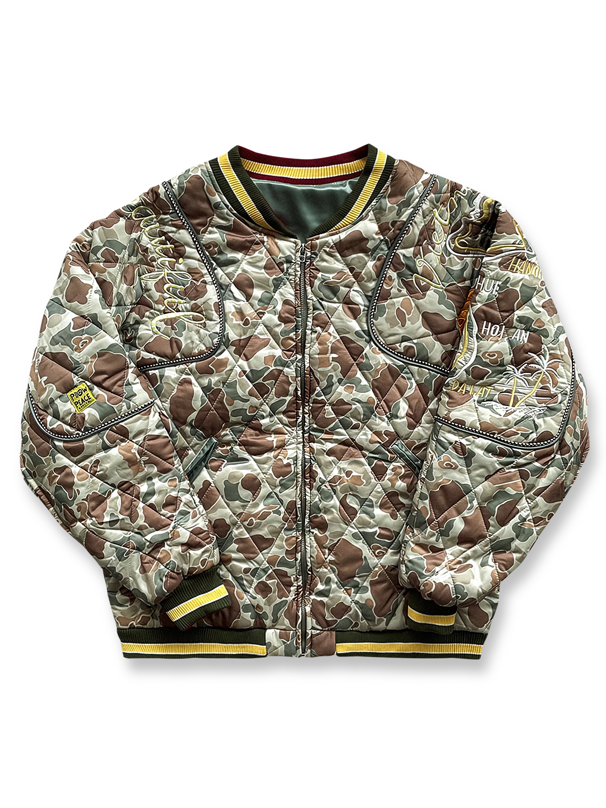 カモフラージュ柄と刺繍が特徴のベースボールジャケット。ストライプリブと多ポケット付きの防寒デザイン。