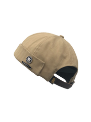 キャンバス素材と金属バッジを組み合わせたビーニースタイルのベレー帽