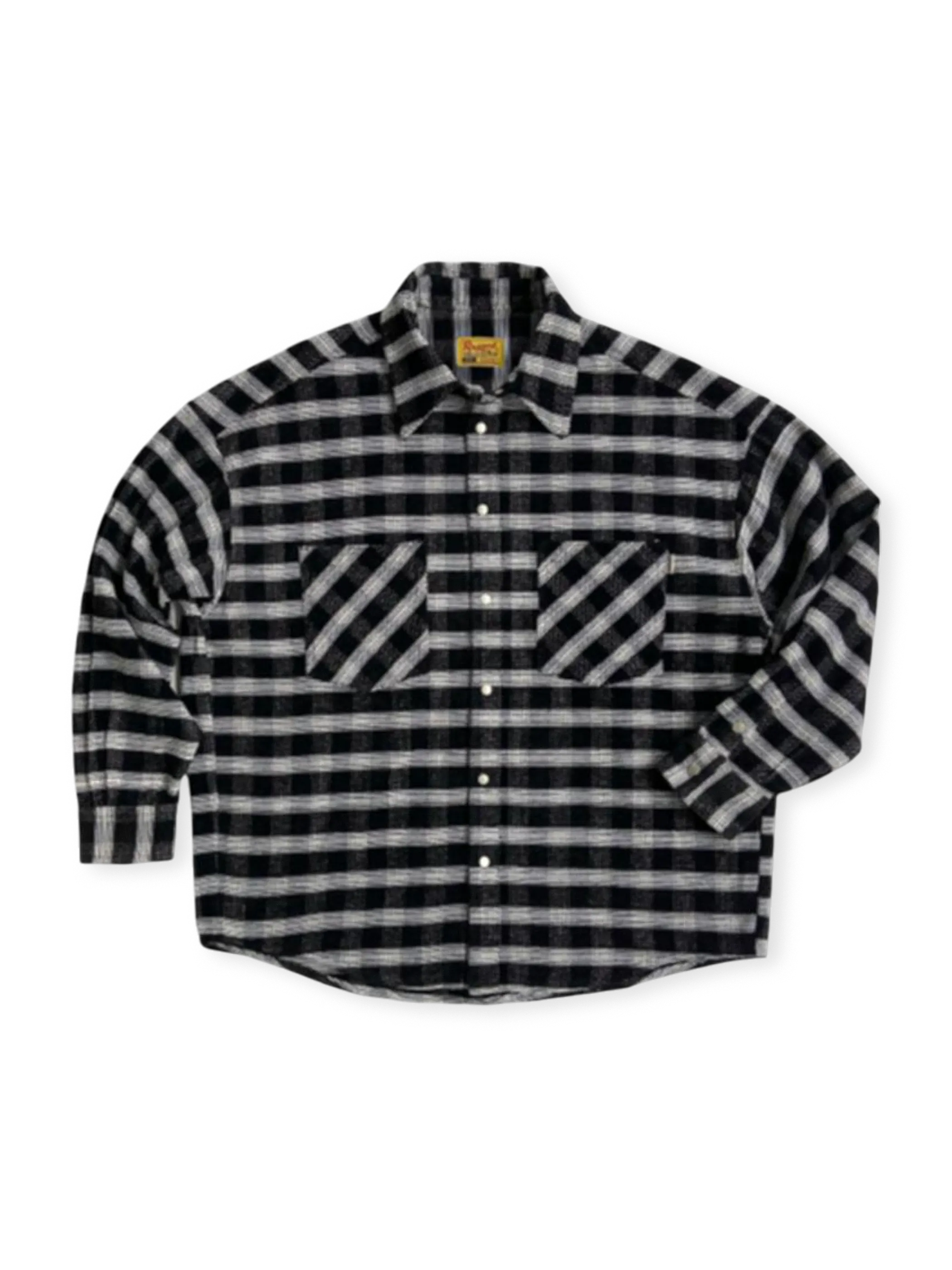 チカーノ美学とアメリカンワークウェア融合のフランネルシャツ。45度ポケットと刺繍入り襟裏が特徴。