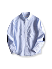 カラーブロックパッチとX刺繍ポケットが特徴の純綿オックスフォードシャツ。