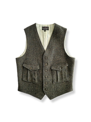 ダークグリーンのヘリンボーンツイード織りウールベスト、前面に複数ポケット付き。