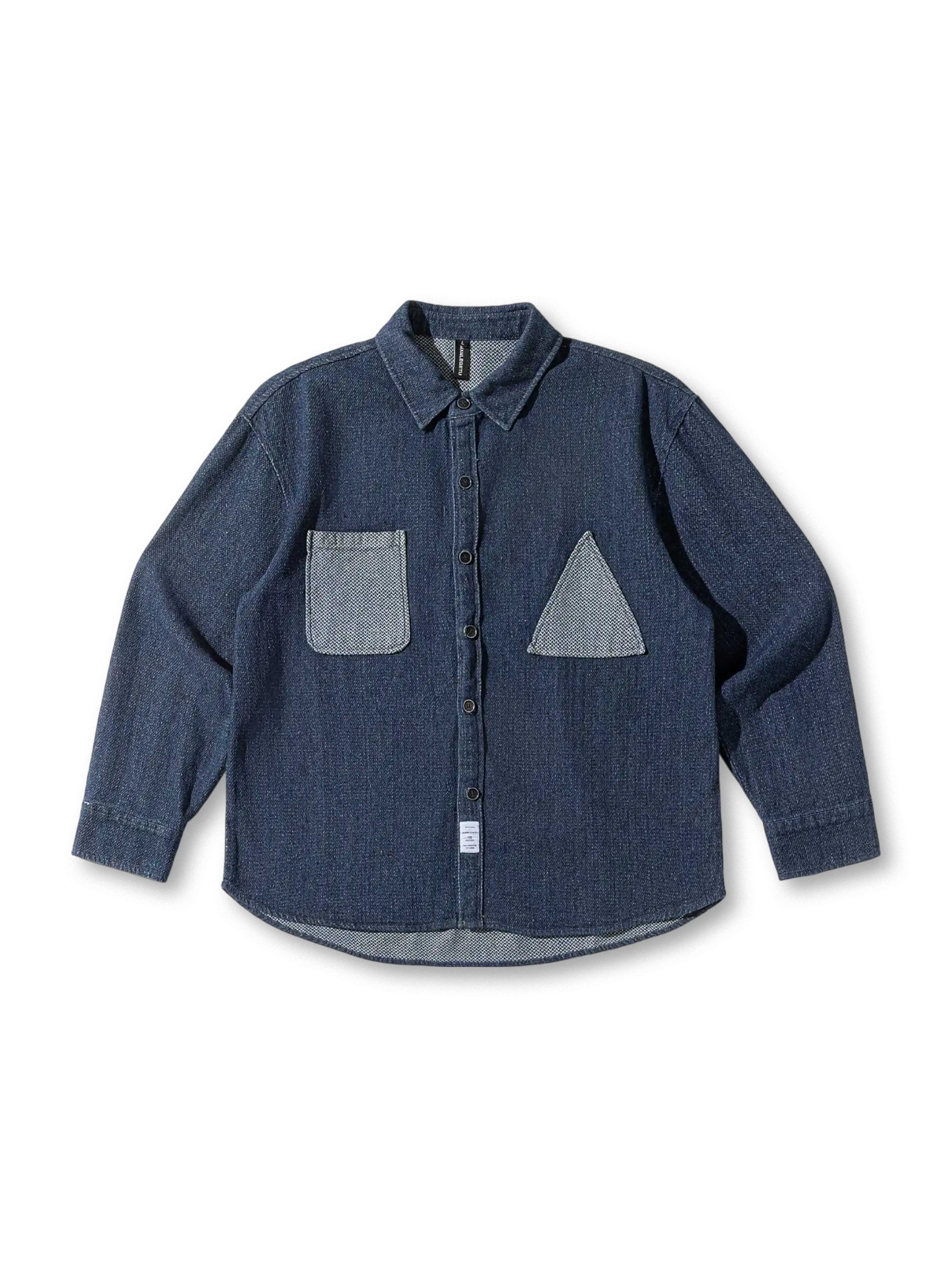 異素材パッチワークとゆったりシルエットが特徴のデニムシャツ。耐久性と個性を兼ね備えた一着。