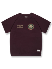 胸元に刺繍バッジが付いたラグランスリーブの半袖Tシャツ。