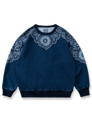 民族風抜染パターンを施したインディゴウォッシュ加工のスウェット。100%コットン素材とゆったりシルエットを特徴とするアイテム。