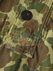 製品画像: 迷彩柄ツイルデニム生地の砲兵防護プルオーバーパーカー復刻バージョンの正面画像。
詳細画像: 大きなフードと三層前立てデザインのディテール特写。機能性とヴィンテージ感が際立つディテール。