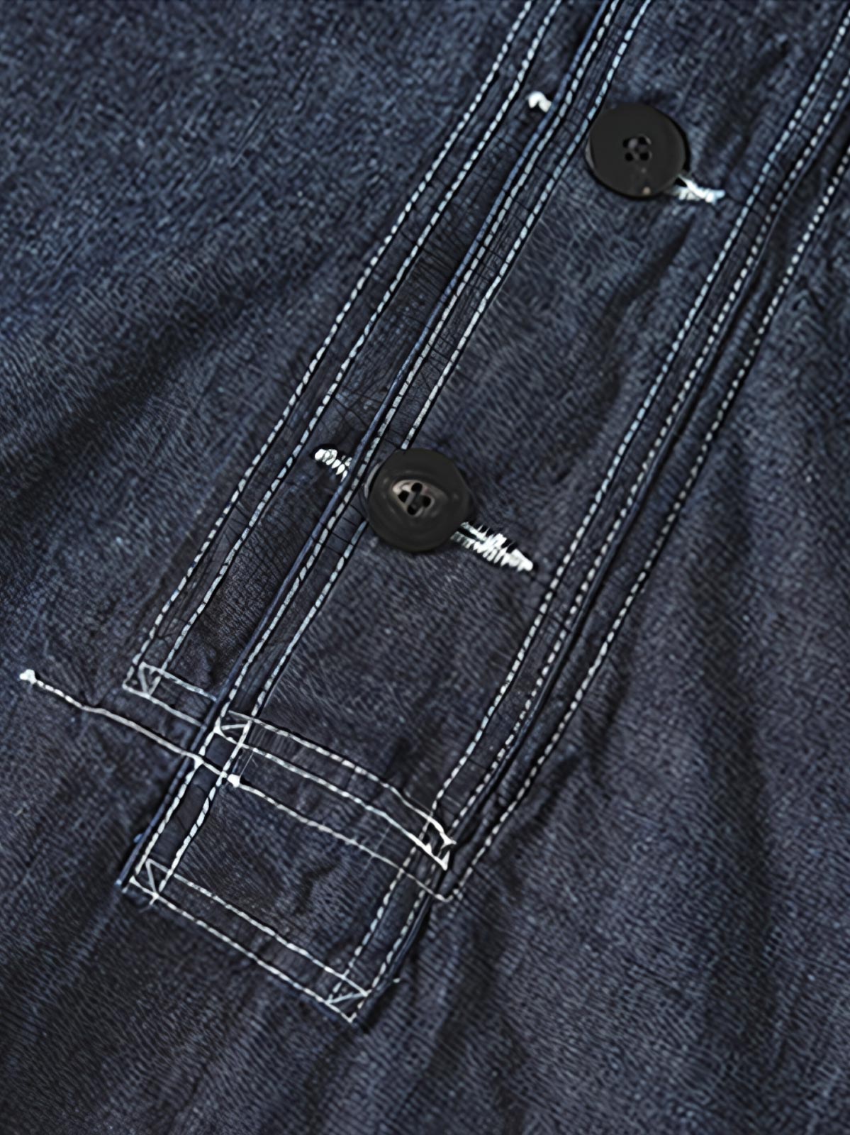 製品画像: 迷彩柄ツイルデニム生地の砲兵防護プルオーバーパーカー復刻バージョンの正面画像。
詳細画像: 大きなフードと三層前立てデザインのディテール特写。機能性とヴィンテージ感が際立つディテール。