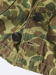 製品画像: 迷彩柄ツイルデニム生地の砲兵防護プルオーバーパーカー復刻バージョンの正面画像。
詳細画像: 大きなフードと三層前立てデザインのディテール特写。機能性とヴィンテージ感が際立つディテール。