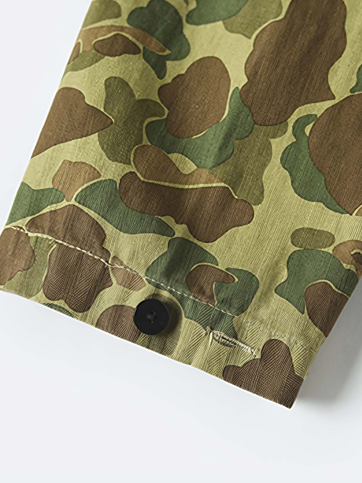 製品画像: 迷彩柄ツイルデニム生地の砲兵防護プルオーバーパーカー復刻バージョンの正面画像。
詳細画像: 大きなフードと三層前立てデザインのディテール特写。機能性とヴィンテージ感が際立つディテール。