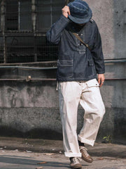 詳細画像: 大きなフードと三層前立てデザインのディテール特写。機能性とヴィンテージ感が際立つディテール。
モデル画像: モデルが迷彩柄砲兵防護プルオーバーパーカーを着用したスタイリング例。戦時風デザインを取り入れたコーディネート。