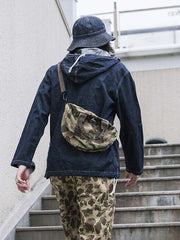 詳細画像: 大きなフードと三層前立てデザインのディテール特写。機能性とヴィンテージ感が際立つディテール。
モデル画像: モデルが迷彩柄砲兵防護プルオーバーパーカーを着用したスタイリング例。戦時風デザインを取り入れたコーディネート。