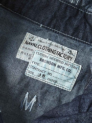 製品画像: 迷彩柄ツイルデニム生地の砲兵防護プルオーバーパーカー復刻バージョンの正面画像。
詳細画像: 大きなフードと三層前立てデザインのディテール特写。機能性とヴィンテージ感が際立つディテール。