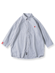 赤いアクセントが入った五分袖のストライプシャツ