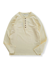ヘンリーネックとボタンディテールが特徴の米色の100%コットン長袖Tシャツの全体像。