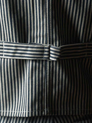 詳細画像: ベストのポケットとストライプ生地のディテール。堅牢で耐摩耗性に優れたHICKORYストライプ生地を使用。
モデル画像: モデルが着用するHICKORY鉄道ストライプワークベスト 復刻バージョンのスタイリング例。ヴィンテージスタイルやカジュアルスタイルに最適。