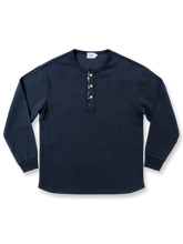 藍染古布襟とワッフル編みを施したヘンリーネック長袖Tシャツ。カーブ裾とココナッツボタンが特徴のユニセックスデザイン。