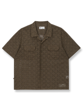 レース刺繍が施されたコットンニットシャツ。