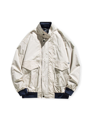 大容量フラップポケットとスタンドカラーを持つ耐摩耗ポリエステル製ワークジャケット。伸縮性リブ袖口と裾が特徴。