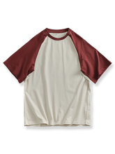 ラグランスリーブとバイカラー切り替えが特徴のルーズフィットコットンTシャツ。
