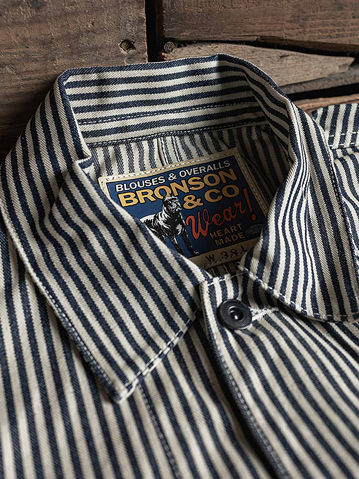 製品画像: LOT422 HICKORY レイルロードストライプワークジャケットの正面画像。クラシックなワークスタイルと希少なセルビッジデニムが特徴。
詳細画像: セルビッジエッジとストライプデニム生地のディテール特写。ヴィンテージ感と耐久性を兼ね備えたデザイン。