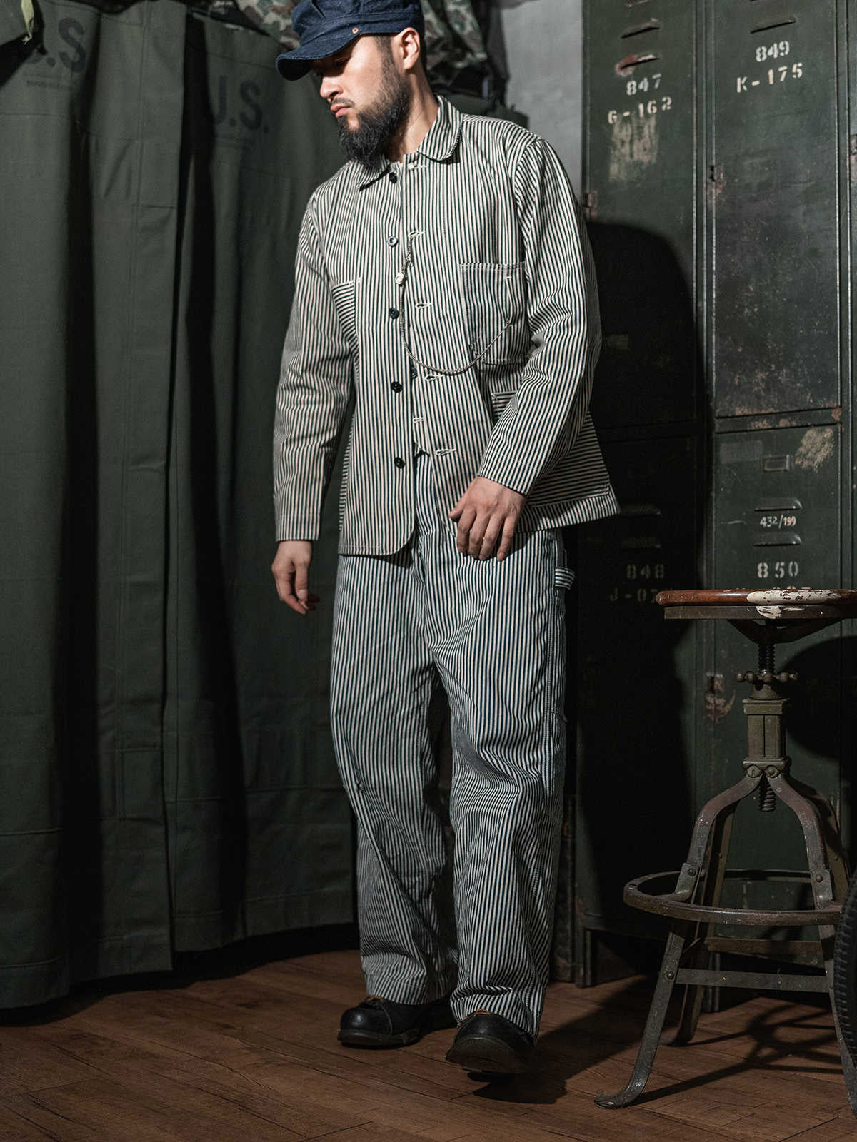 詳細画像: セルビッジエッジとストライプデニム生地のディテール特写。ヴィンテージ感と耐久性を兼ね備えたデザイン。
モデル画像: モデルが着用したLOT422 HICKORY レイルロードストライプワークジャケット。堅牢でスタイリッシュなワークスタイルを演出。