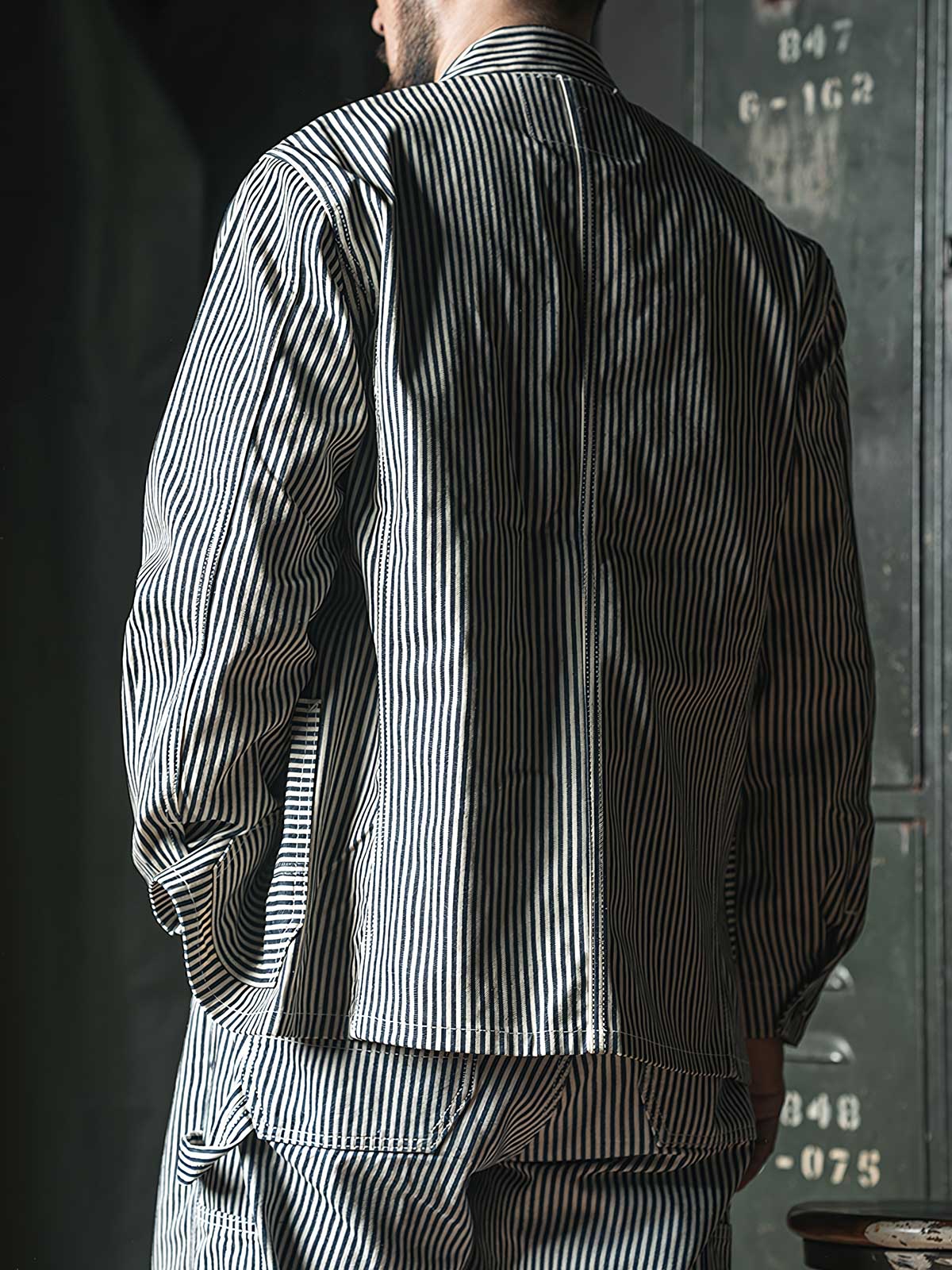 詳細画像: セルビッジエッジとストライプデニム生地のディテール特写。ヴィンテージ感と耐久性を兼ね備えたデザイン。
モデル画像: モデルが着用したLOT422 HICKORY レイルロードストライプワークジャケット。堅牢でスタイリッシュなワークスタイルを演出。