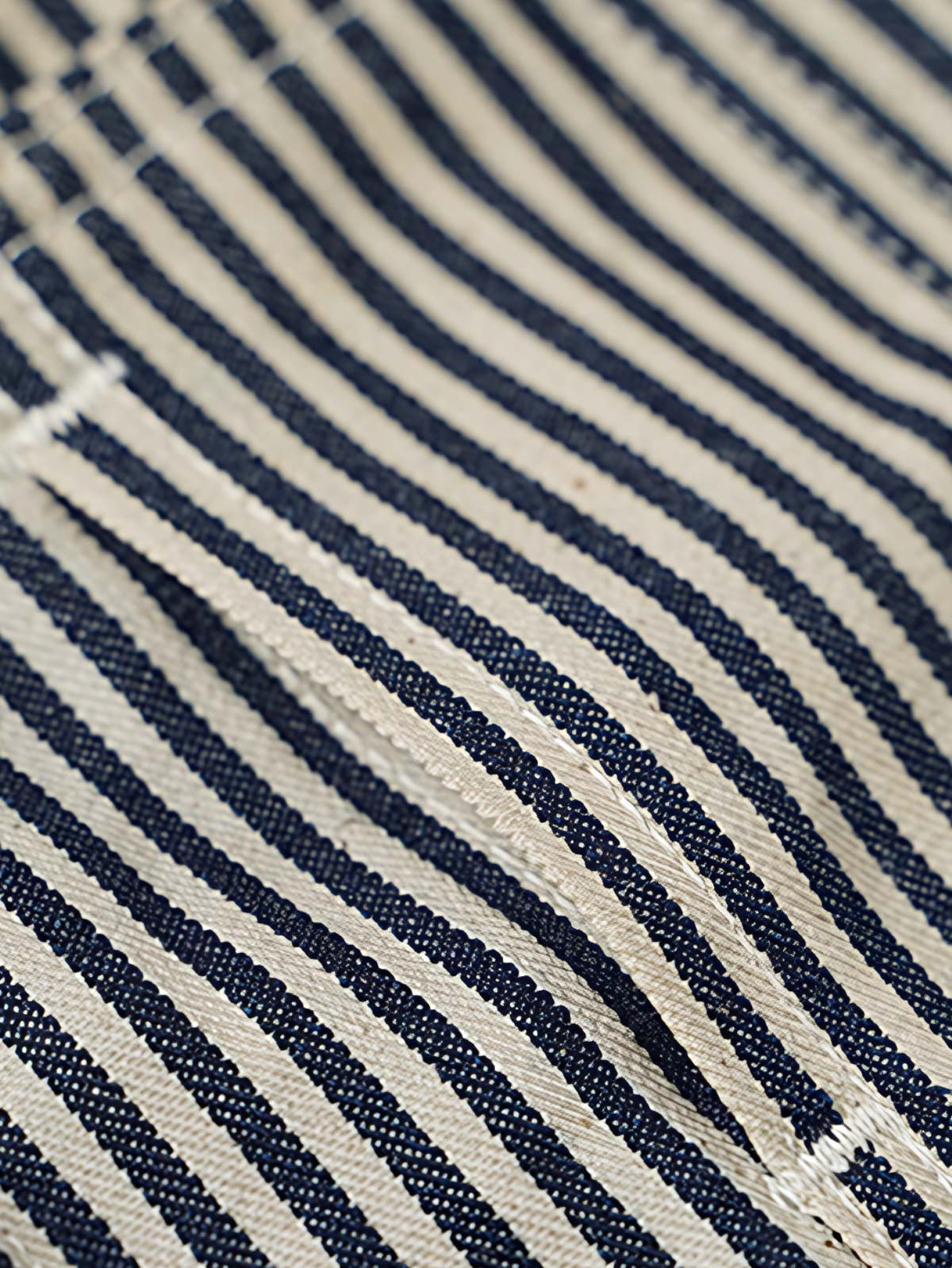 製品画像: LOT422 HICKORY レイルロードストライプワークジャケットの正面画像。クラシックなワークスタイルと希少なセルビッジデニムが特徴。
詳細画像: セルビッジエッジとストライプデニム生地のディテール特写。ヴィンテージ感と耐久性を兼ね備えたデザイン。