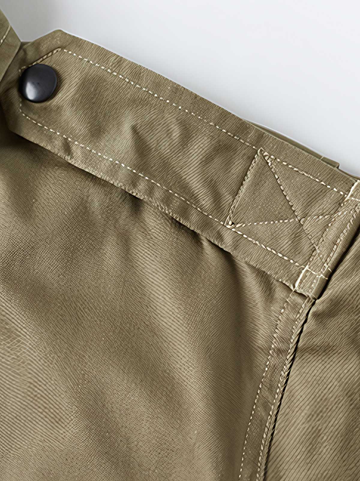 製品画像: M-42パラシュートジャケットの正面画像。ヴィンテージミリタリースタイルが際立つ高光沢ツイルコットンジャケット。
詳細画像: ジャケットのポケットとウエストベルトのディテール。機能性とデザイン性を兼ね備えたディテール。