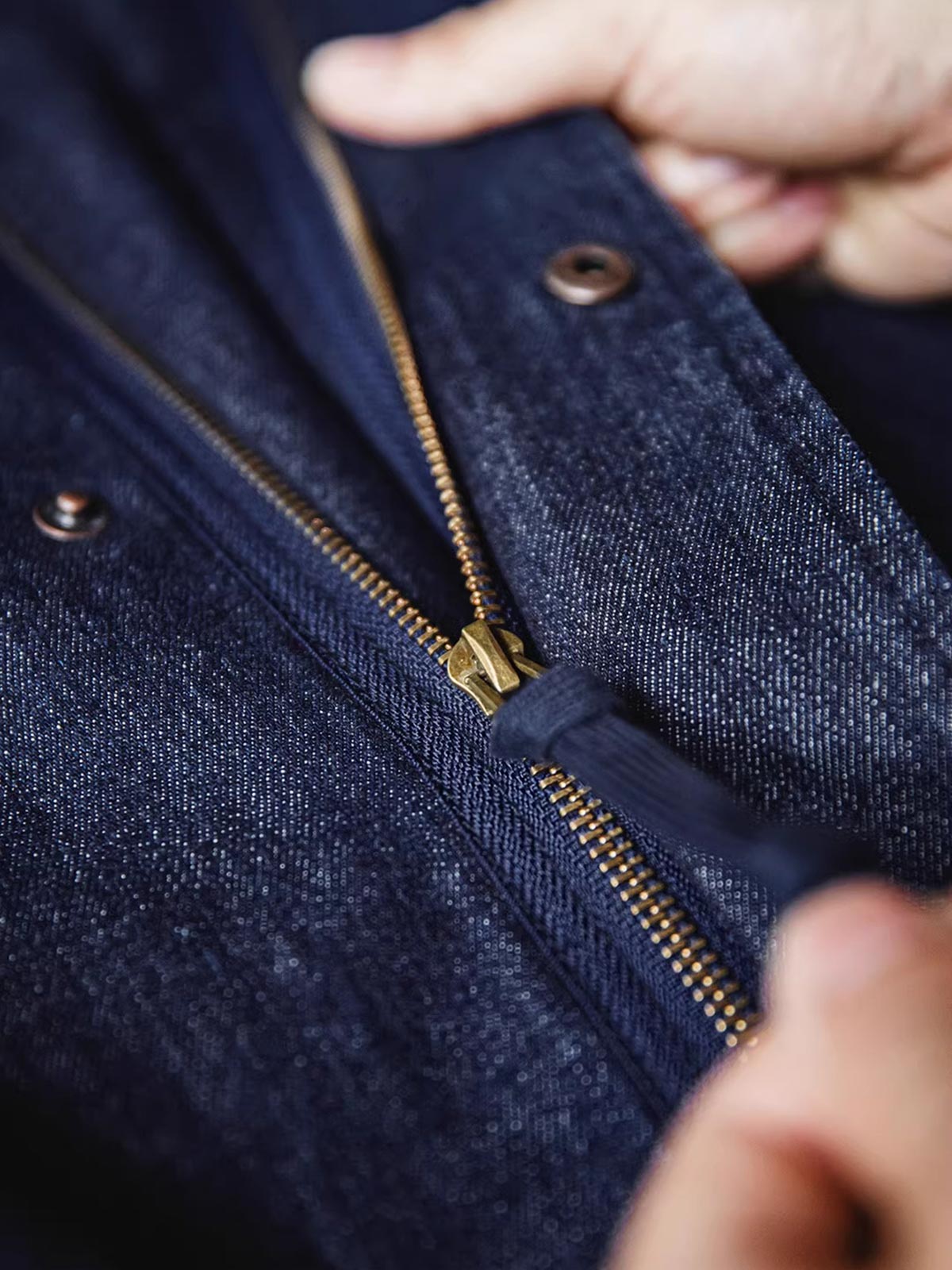 製品画像: M51デニムフィッシュテール パーカ(フード付き)の全体像を正面から撮影した画像
詳細画像: 青銅色のジッパーとフィッシュテールデザインを強調したディテール画像