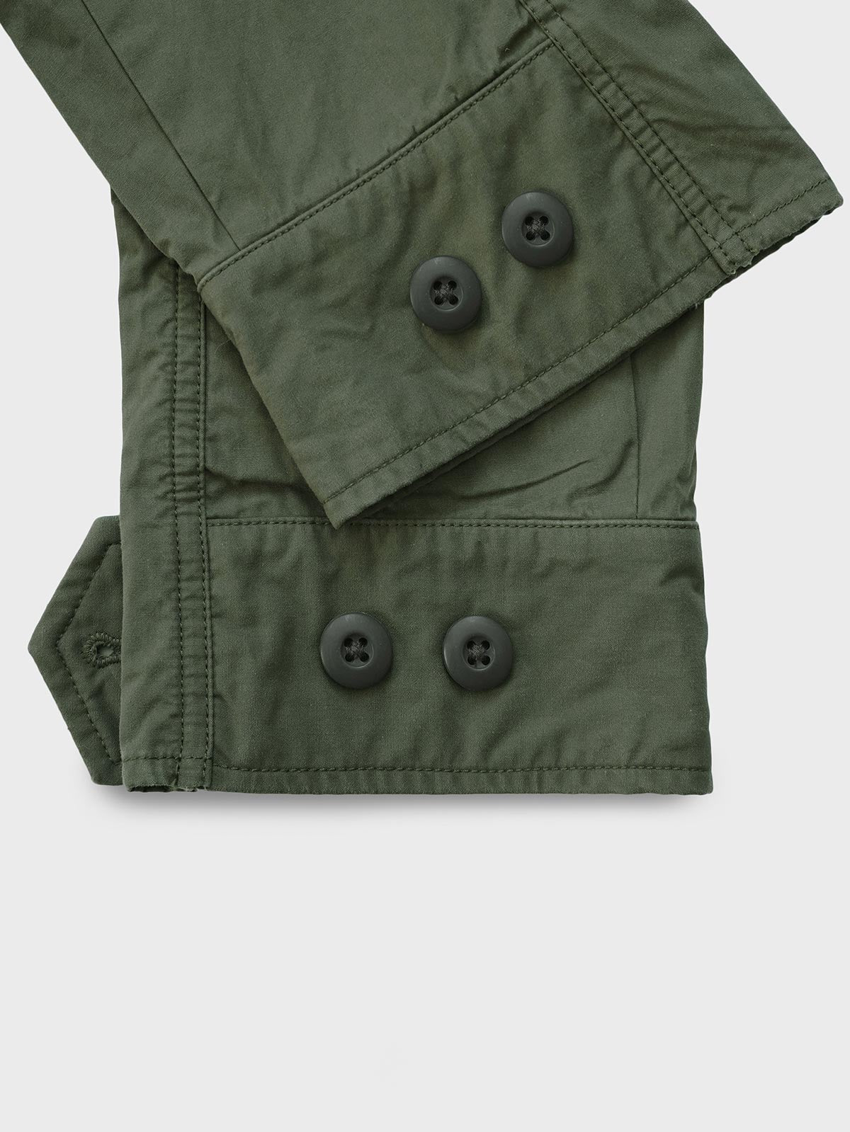 製品画像:M65 EVO 70s アメカジ ヴィンテージ フィンコットン トレンチコートの正面画像です。ヴィンテージ風の独特な風合いが特徴です。
詳細画像:M65トレンチコートのディテールとポケットデザインの詳細画像です。実用性とデザイン性を兼ね備えたアイテムです。