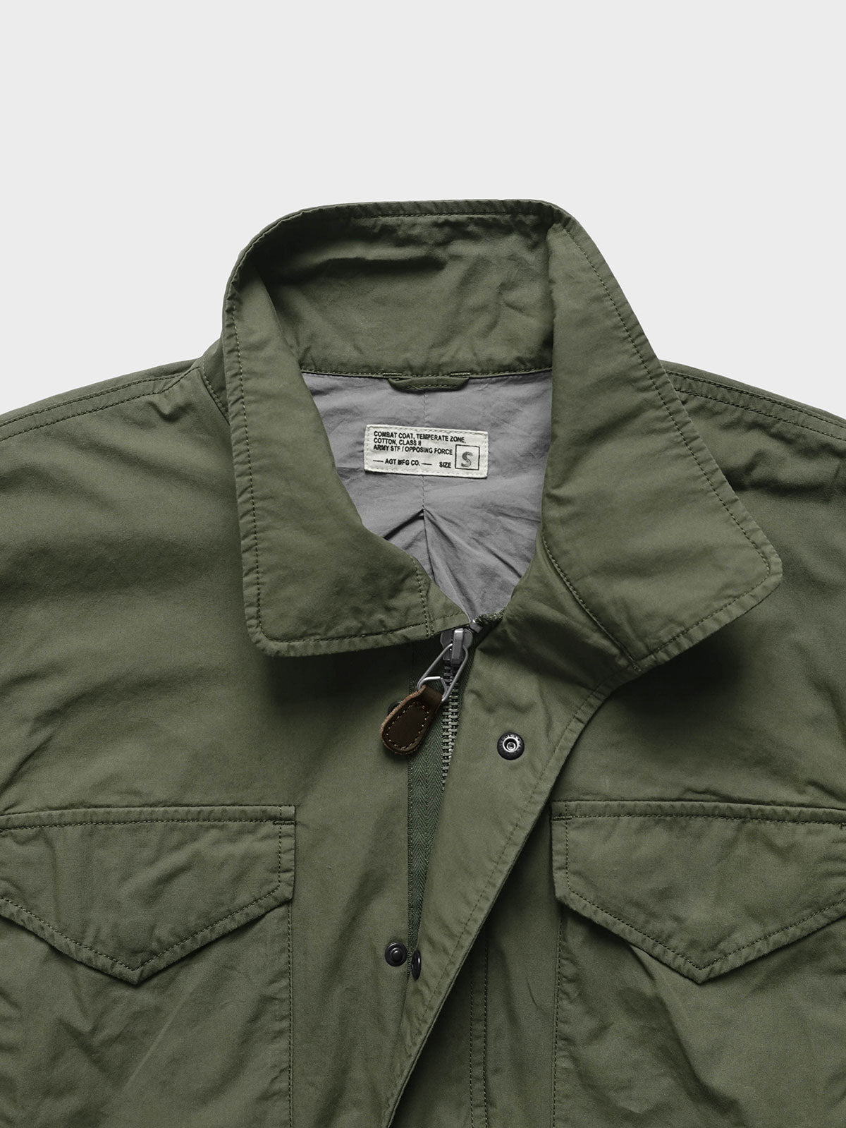 製品画像:M65 EVO 70s アメカジ ヴィンテージ フィンコットン トレンチコートの正面画像です。ヴィンテージ風の独特な風合いが特徴です。
詳細画像:M65トレンチコートのディテールとポケットデザインの詳細画像です。実用性とデザイン性を兼ね備えたアイテムです。