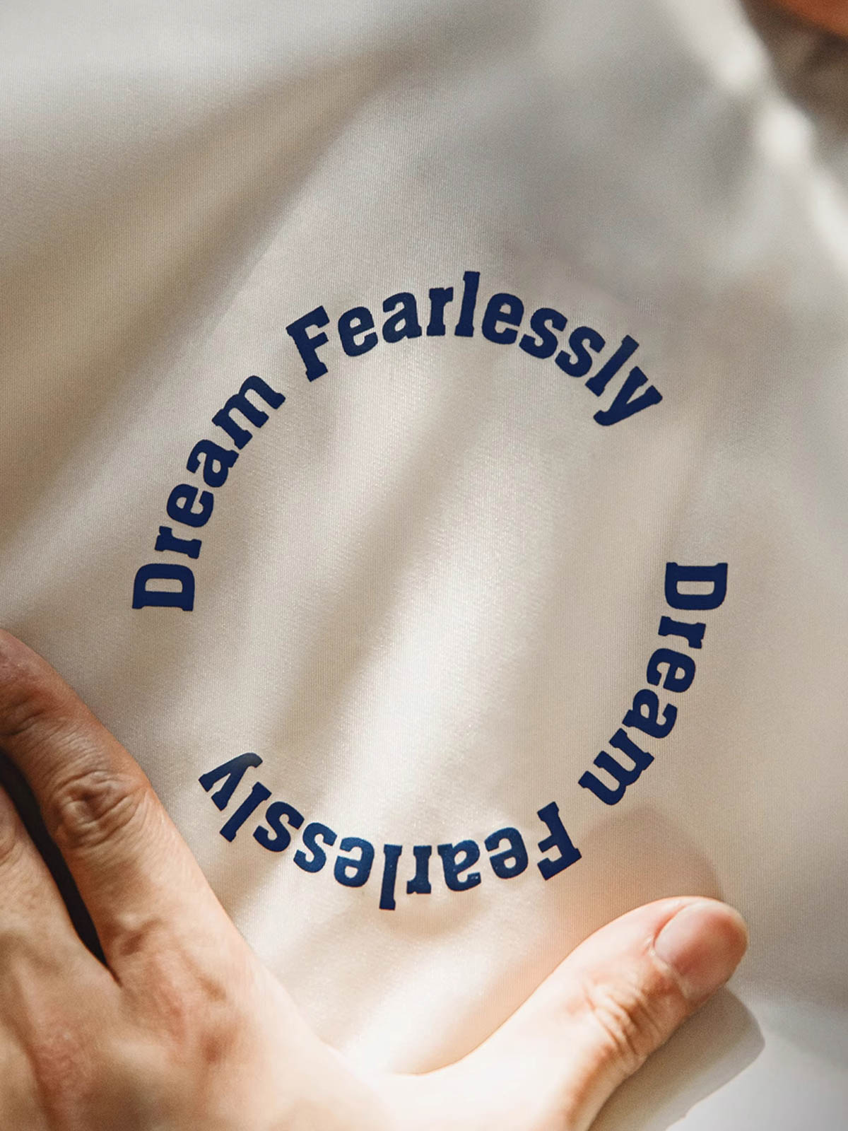 胸元のベルクロスローガンとアームポケットジッパーの詳細画像