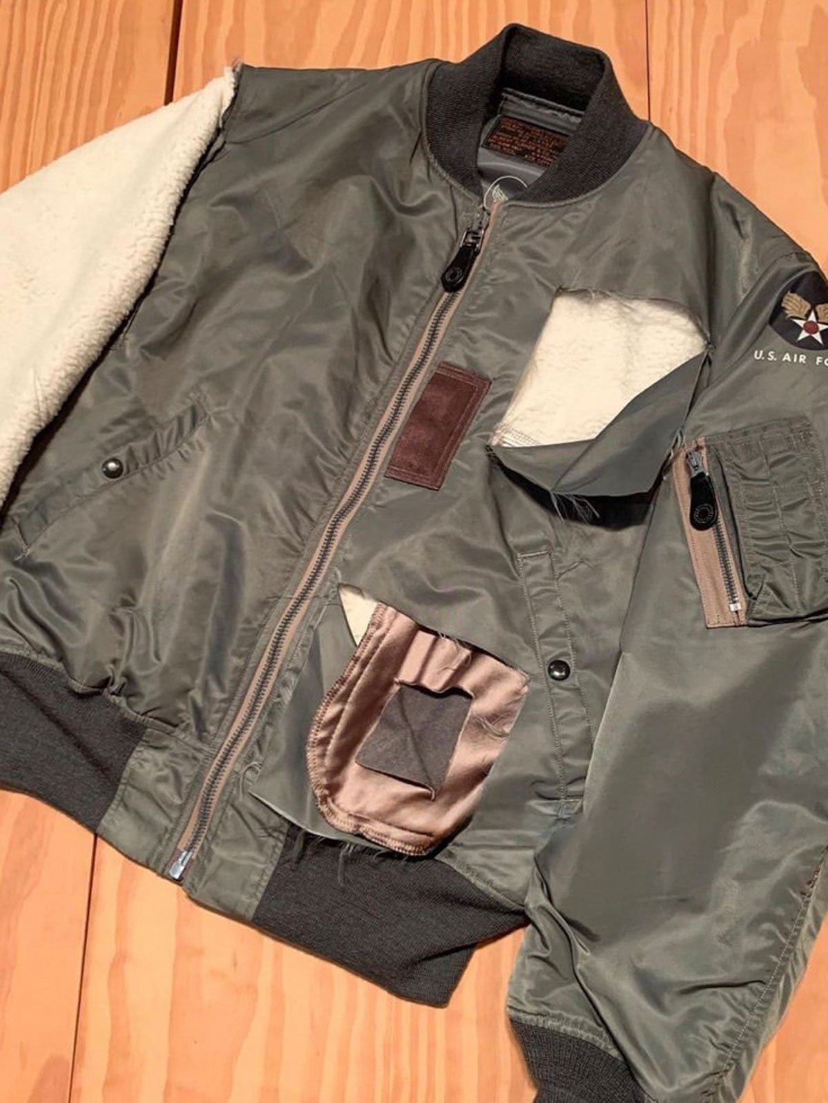 製品画像: 両面ウール使用のMA-1リバーシブルミリタリーフライトジャケット全体画像
詳細画像: フライトバッジとIDEAL製レザー引手のディテール画像