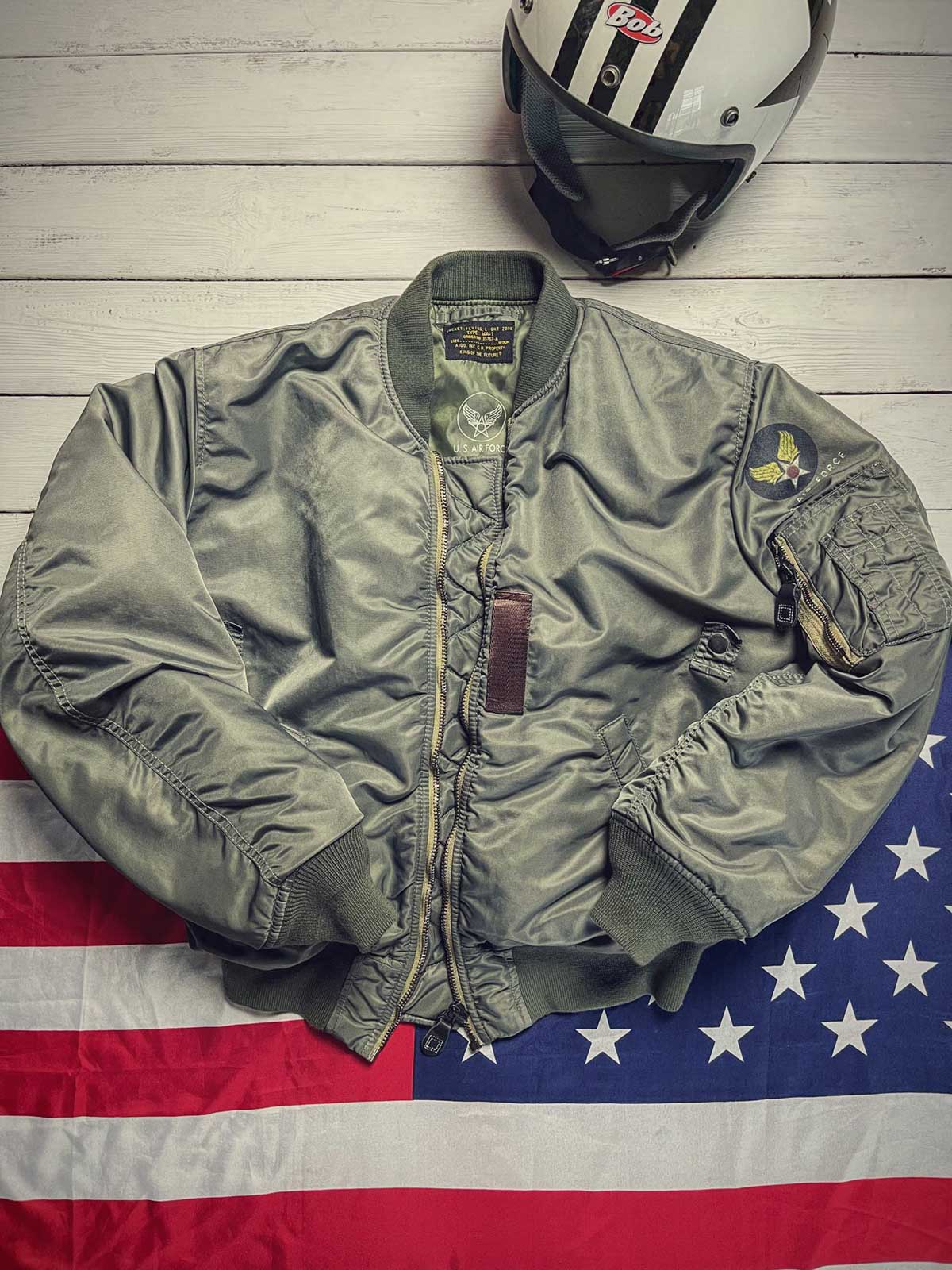 製品画像: 両面ウール使用のMA-1リバーシブルミリタリーフライトジャケット全体画像
詳細画像: フライトバッジとIDEAL製レザー引手のディテール画像