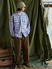 詳細画像: キューバンカラーと胸前のフラップポケットのディテール。チェック柄の鮮明さとシャツの質感を強調。
モデル画像: モデルがMADRAS (マドラス) チェック柄シャツを着用したスタイリング例。実際の着用感やフィット感を視覚的に伝える。