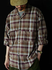 詳細画像: キューバンカラーと胸前のフラップポケットのディテール。チェック柄の鮮明さとシャツの質感を強調。
モデル画像: モデルがMADRAS (マドラス) チェック柄シャツを着用したスタイリング例。実際の着用感やフィット感を視覚的に伝える。