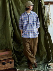 詳細画像: キューバンカラーと胸前のフラップポケットのディテール。チェック柄の鮮明さとシャツの質感を強調。
モデル画像: モデルがMADRAS (マドラス) チェック柄シャツを着用したスタイリング例。実際の着用感やフィット感を視覚的に伝える。