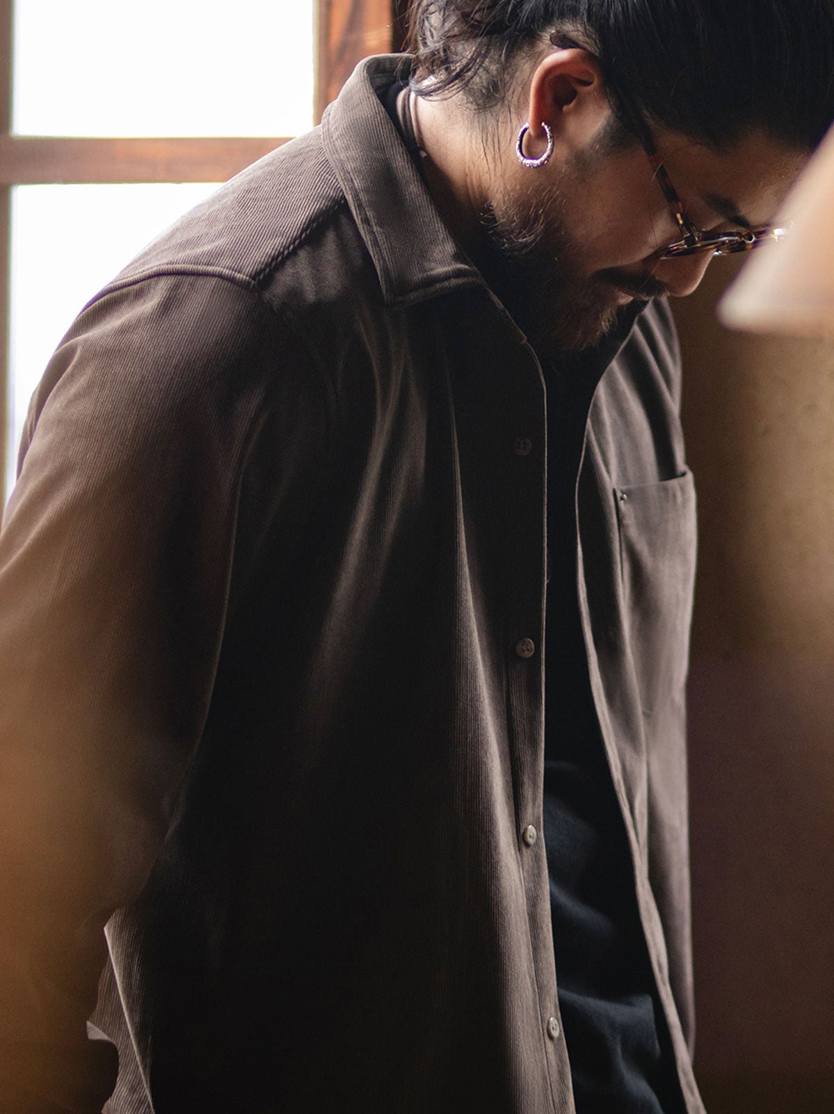 詳細画像:胸元のリベットデザインと裾のNAVAJOラベル。ヴィンテージ感のあるディテール。
モデル画像:モデルが着用したコーデュロイシャツの全身コーディネート。秋冬向けのカジュアルなルーズフィットスタイル。