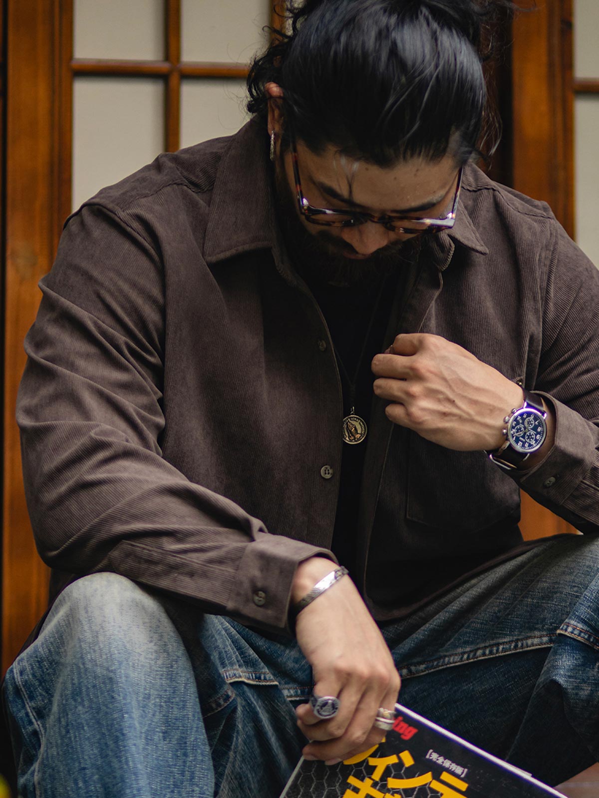 詳細画像:胸元のリベットデザインと裾のNAVAJOラベル。ヴィンテージ感のあるディテール。
モデル画像:モデルが着用したコーデュロイシャツの全身コーディネート。秋冬向けのカジュアルなルーズフィットスタイル。