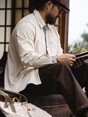 詳細画像:胸元のリベットデザインと裾のNAVAJOラベル。ヴィンテージ感のあるディテール。
モデル画像:モデルが着用したコーデュロイシャツの全身コーディネート。秋冬向けのカジュアルなルーズフィットスタイル。