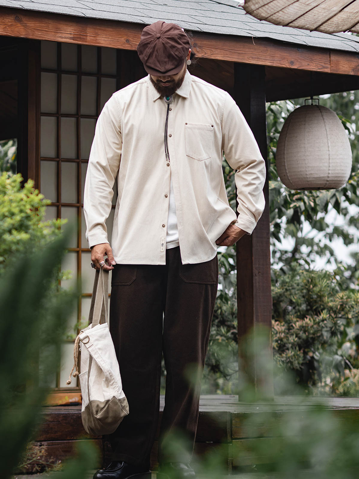 詳細画像:胸元のリベットデザインと裾のNAVAJOラベル。ヴィンテージ感のあるディテール。
モデル画像:モデルが着用したコーデュロイシャツの全身コーディネート。秋冬向けのカジュアルなルーズフィットスタイル。