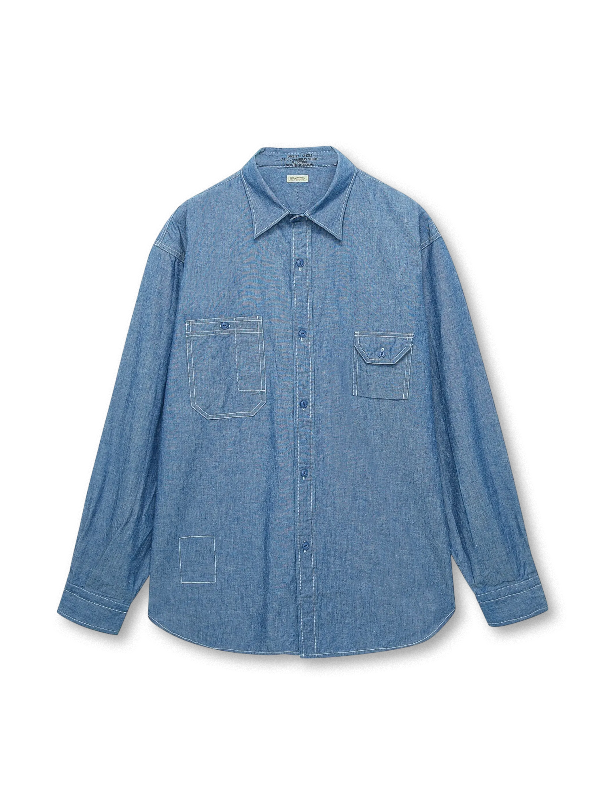 岡山県井原市の旧式力織機で織られた純綿チャンブレー生地を使用し、伝統的なアメリカンワークシャツのディテールを備えたヴィンテージ風ワークシャツ。胸ポケットと魚眼スナップボタンが特徴。