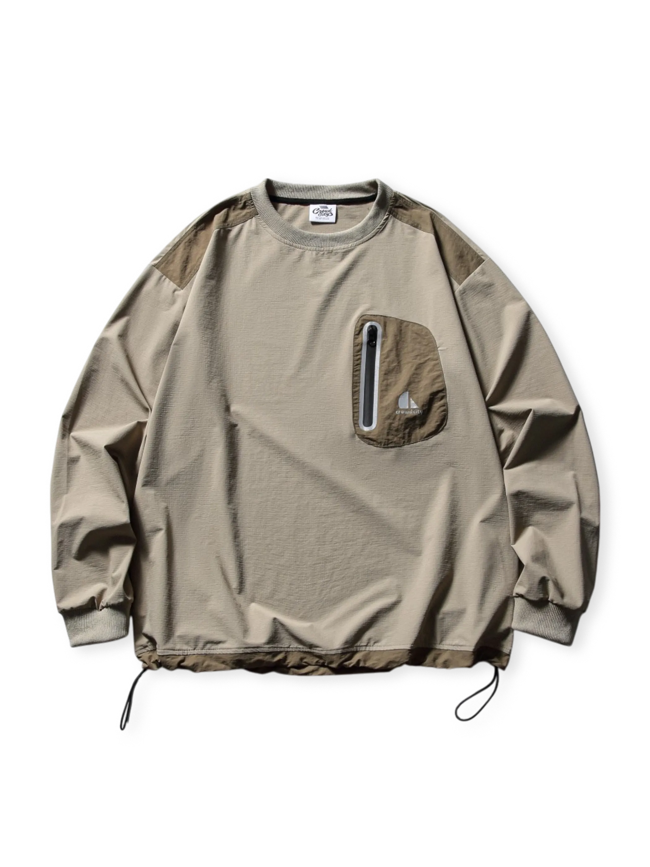 ナイロン混紡生地のロングスリーブTシャツ。胸にナイロンパッチポケットとジップ、ドローコード裾とエラスティック袖口が特徴。