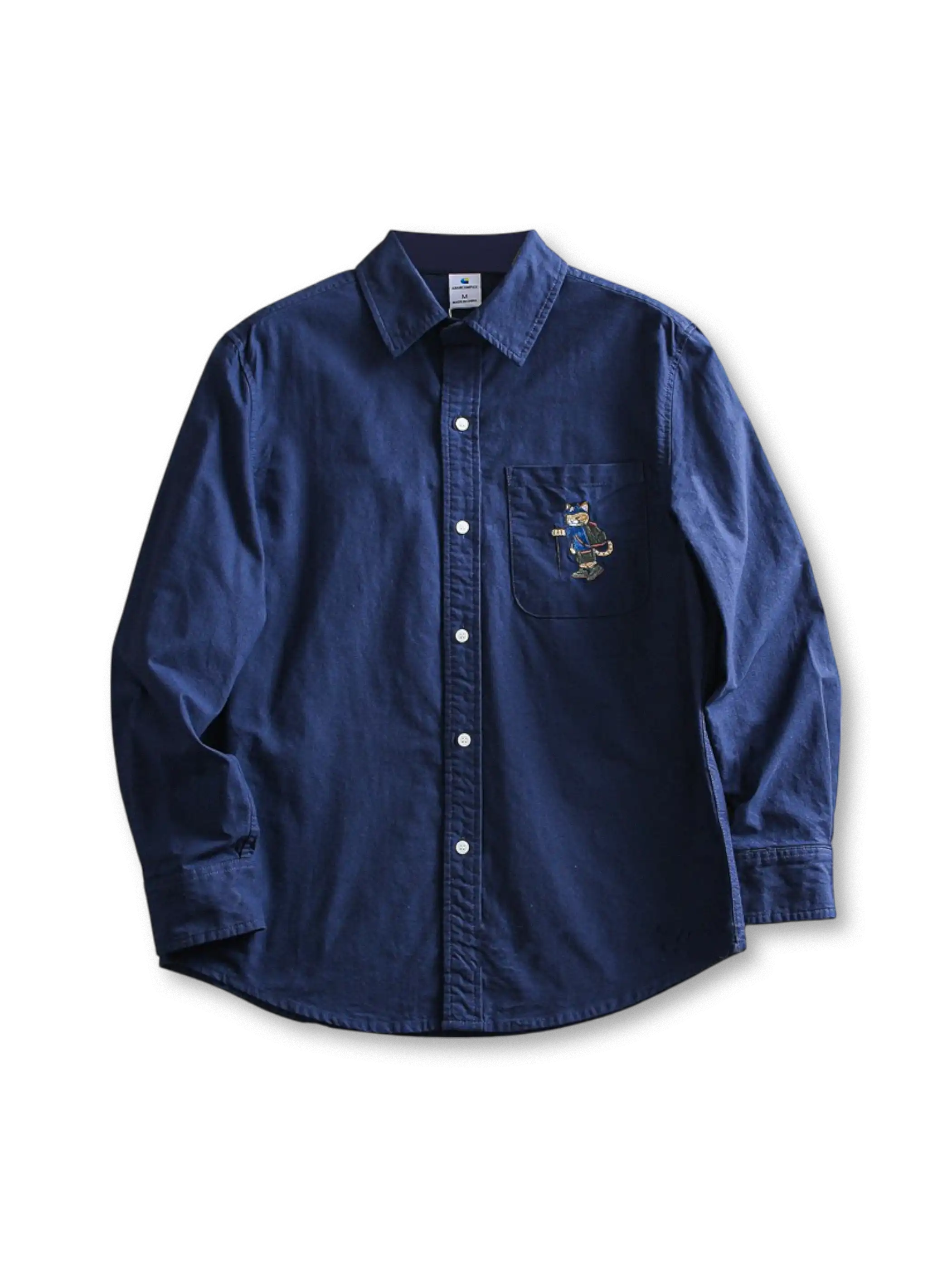 水洗い加工のコットンオックスフォード生地と猫刺繍が特徴のゆったりシルエットシャツ。多用途に活躍。