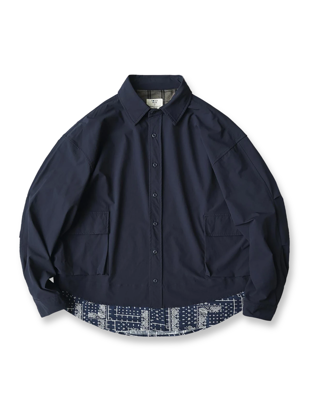 ペイズリー柄パッチワークを裾に施したレイヤード風の長袖シャツ。高性能ナイロン混紡素材で滑らかな肌触りと優れたドレープ感を持ち、大容量ポケットと日本製スナップボタンを備えた実用的なデザイン。オーバーサイズシルエットで快適な着心地。