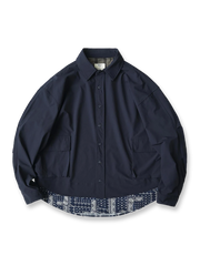 ペイズリー柄パッチワークを裾に施したレイヤード風の長袖シャツ。高性能ナイロン混紡素材で滑らかな肌触りと優れたドレープ感を持ち、大容量ポケットと日本製スナップボタンを備えた実用的なデザイン。オーバーサイズシルエットで快適な着心地。